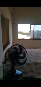 a fan sitting on a table in a room with a bed at RECANTO DO SOL SABIAGUABA CEARA in Fortaleza