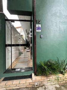 una entrada a un edificio con una puerta verde en Morada do Sol Suítes en Arraial do Cabo