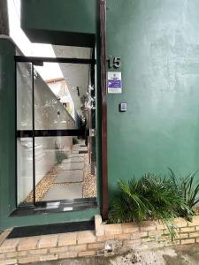 an entrance to a building with a green door at Morada do Sol Suítes in Arraial do Cabo