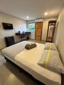a bedroom with a large bed and a desk at Morada do Sol Suítes in Arraial do Cabo