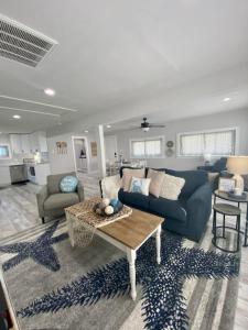 a living room with a blue couch and a table at Sandy Haven in Bolivar Peninsula