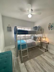 a bedroom with a bunk bed with a ceiling fan at Sandy Haven in Bolivar Peninsula