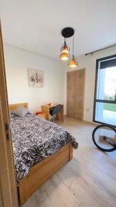 a bedroom with a bed and a bicycle in it at Appartement Prestigia des nations in Salé