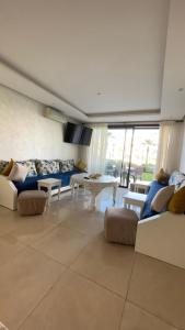 a large living room with couches and a table at Appartement Prestigia des nations in Salé