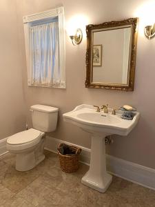 y baño con aseo, lavabo y espejo. en Historic Queen Anne Mansion, en Quincy