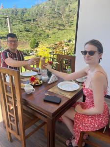 een man en een vrouw aan een tafel bij Queensland Hotel in Nuwara Eliya