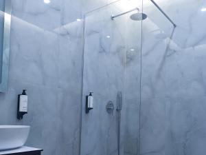 a shower with a glass door in a bathroom at Star Hotel Astir in Tirana