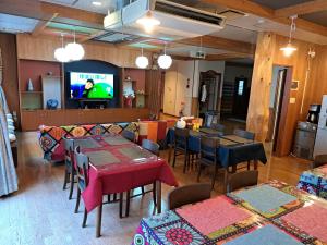 un restaurante con mesas y sillas y TV de pantalla plana en 大山ベースキャンプ（Daisen Basecamp） en Daisen