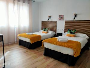 two beds in a room with wooden floors at El Pardo in Haro