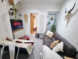 uma sala de estar com um sofá de couro e uma televisão em 4bed/3bath 8min to London Bridge em Londres