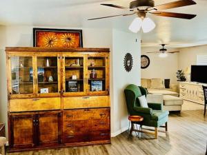 a living room with a large wooden cabinet and a chair at The Lighthouse Pet Friendly Hot Tub BBQ Sleeps 11 in Coarsegold