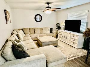 a living room with a couch and a flat screen tv at The Lighthouse Pet Friendly Hot Tub BBQ Sleeps 11 in Coarsegold
