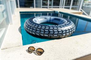 a pair of sunglasses sitting on a table next to a tire at Zuza Slim Suítes in Maceió
