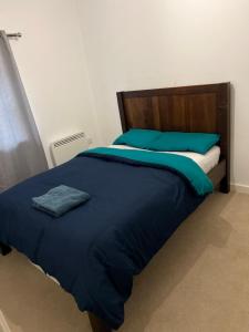 a large bed with blue sheets and blue pillows at Central Town Apartment in Kent