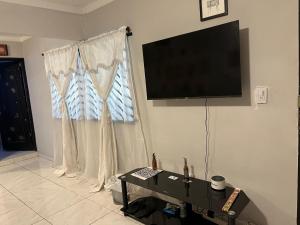 sala de estar con TV de pantalla plana en la pared en Nice Place, en Medellín