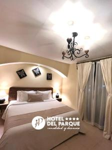 1 dormitorio con cama y lámpara de araña en Hotel Del Parque en Huamantla