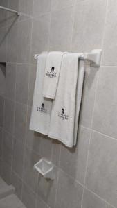 zwei weiße Handtücher hängen an einer Wand im Bad in der Unterkunft HOTEL TAMPICO EXPRESS MORALILLO in Tampico