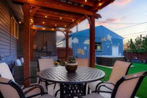 a patio with a table and chairs and a building at One of a Kind Home with HOT TUB Pool Table and Fire Pit 4 Miles to DT in Denver