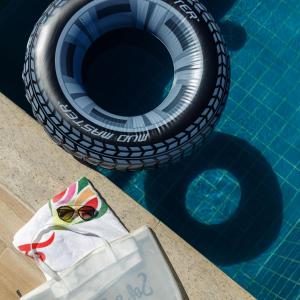un par de gafas de sol sentadas junto a una piscina en Zuza Slim Suítes, en Maceió