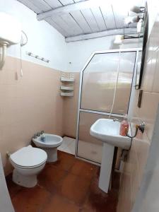 a small bathroom with a toilet and a sink at Casa Ituzaingo Corrientes in Ituzaingó