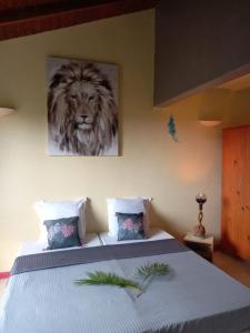 ein Schlafzimmer mit einem Bett mit einem Löwengemälde in der Unterkunft KAZ A PIRATES in Petit-Bourg