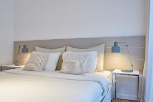 um quarto com uma cama grande e almofadas brancas em Quartier Polo by RentinBA em Buenos Aires