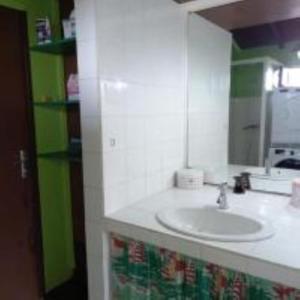 uma casa de banho branca com um lavatório e um espelho em KAZ A PIRATES em Petit-Bourg