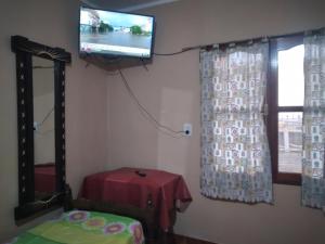 Habitación con TV, mesa y ventana. en HOSTAL LUCERO en Humahuaca