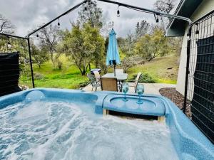 a swimming pool with a table and an umbrella at Lighthouse Suite Pet Friendly Hot Tub Sleeps 4 in Coarsegold