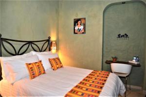 een slaapkamer met een bed en een stoel erin bij Hotel Boutique Casona Cantera Querétaro in Querétaro