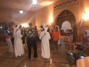 eine Gruppe von Leuten, die in einem Raum tanzen in der Unterkunft SANDSTAR PALACE in Merzouga