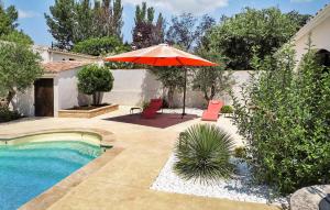 eine Terrasse mit Sonnenschirm und Swimmingpool in der Unterkunft La Musicienne De Paradou in Paradou