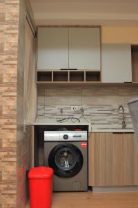 a washing machine in a kitchen with a red trash can at Spacious, beautiful, elegant, with natural light 1 bedroom Apartment in Nairobi