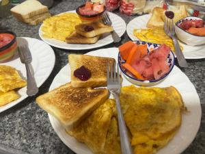 a table with plates of breakfast food with toast and fruit at Apartahotel Bareque centro in Salento