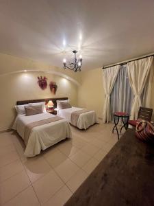 - une chambre avec 2 lits et un lustre dans l'établissement Hotel Del Parque, à Huamantla