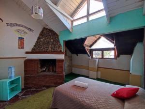 ein Schlafzimmer mit einem Bett und einem gemauerten Kamin in der Unterkunft Cabañas Tres Joyas in San Miguel Regla