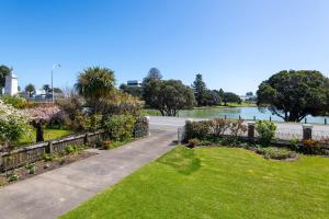 a walkway through a park with a view of a river at Art Deco Charm - Amazing River Views Inner City in Gisborne