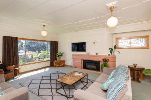 uma sala de estar com um sofá e uma lareira em Art Deco Charm - Amazing River Views Inner City em Gisborne