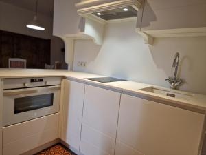 a kitchen with white cabinets and a sink at Biescas Apartamento Casa Josito La Cadiera in Biescas +36 photos