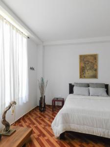 Dormitorio blanco con cama y mesa en Hostal Santa Teresita, en La Merced
