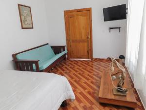 1 dormitorio con cama, mesa y sofá en Hostal Santa Teresita, en La Merced