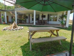una mesa de picnic y una sombrilla frente a una casa en Hostal Santa Teresita, en La Merced