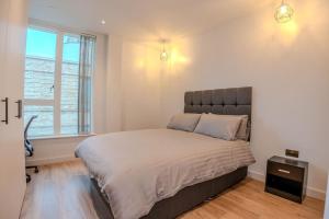 um quarto com uma cama grande e uma janela em 2 Bedroom Flat near Stanmore Station em Stanmore