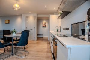 uma cozinha com mesa e cadeiras num quarto em 2 Bedroom Flat near Stanmore Station em Stanmore