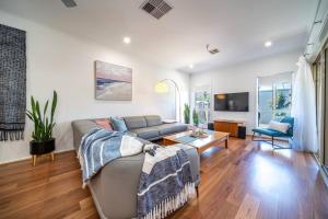 a living room with a couch and a table at Sailors' Retreat - Family Pool Oasis by Largs Beach in Largs