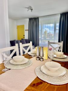 una mesa de comedor con platos y vasos. en Sunshine Retreat Modern 3BR Haven, en St Marys