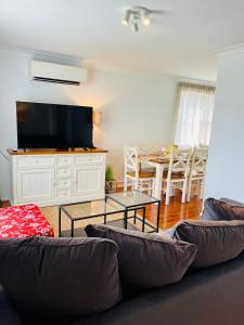 uma sala de estar com um sofá e uma mesa em Sunshine Retreat Modern 3BR Haven em St Marys