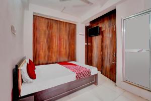 1 dormitorio con 1 cama con pared de madera en OYO Flagship Hotel Celebrate Inn en Patna