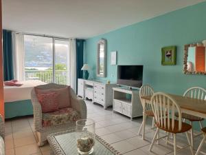 1 dormitorio y sala de estar con sofá y mesa. en Sunset View & Ocean Breeze, en Saint Martin