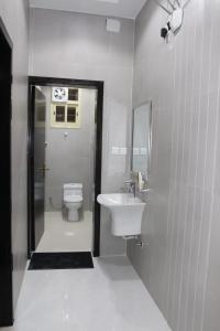 a white bathroom with a sink and a toilet at بارك فيو للوحدات السكنية in Birzayn